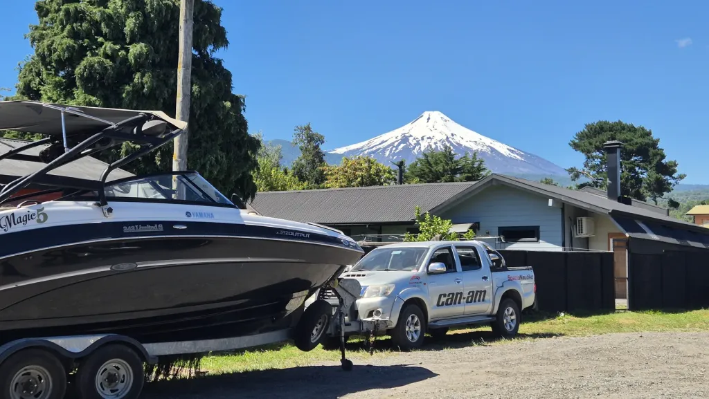 Lancha en el patio del local con el volcán Villarrica al fondo